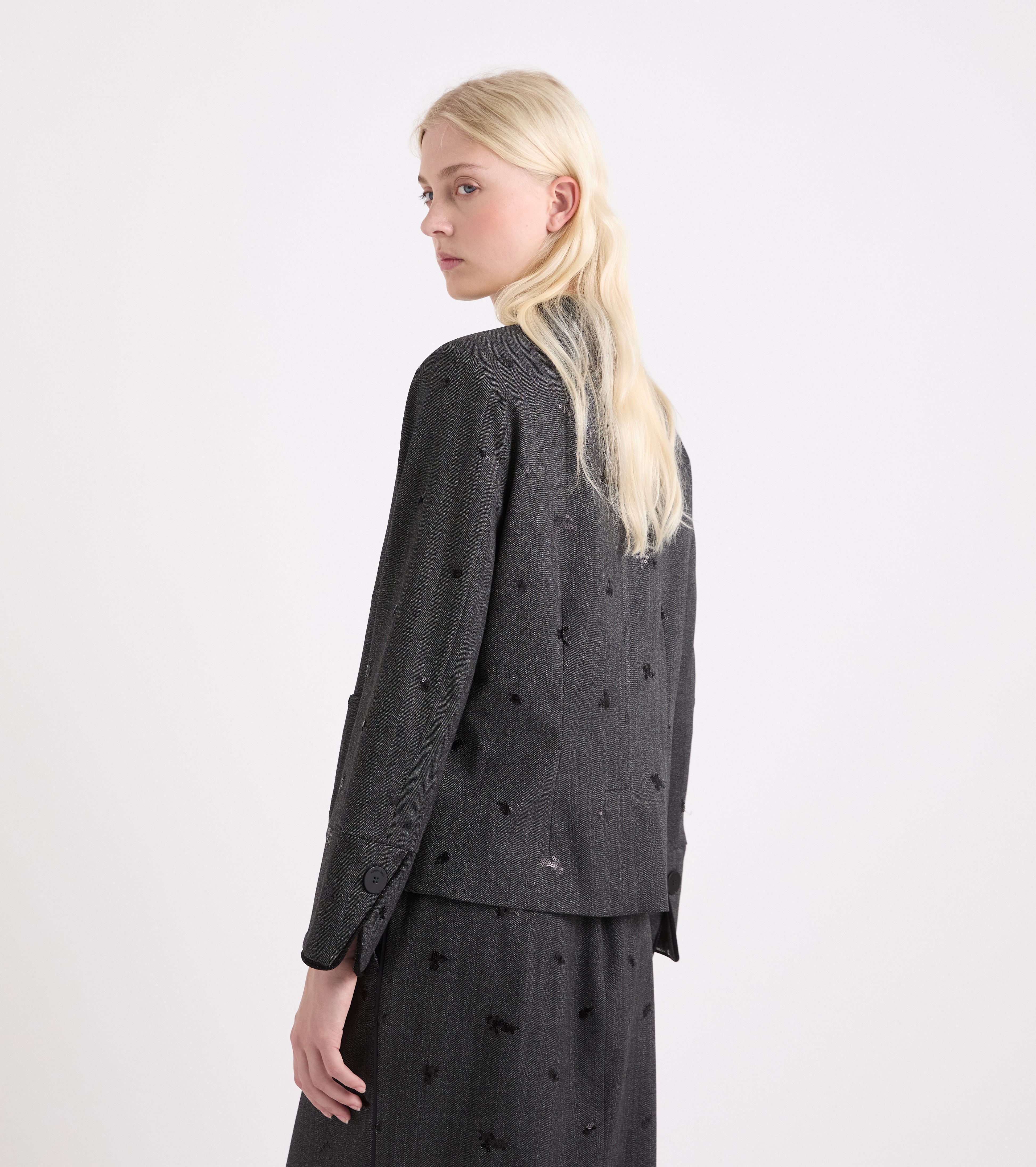 Chaqueta elástica con bordados y botones en tonos sal y pimienta