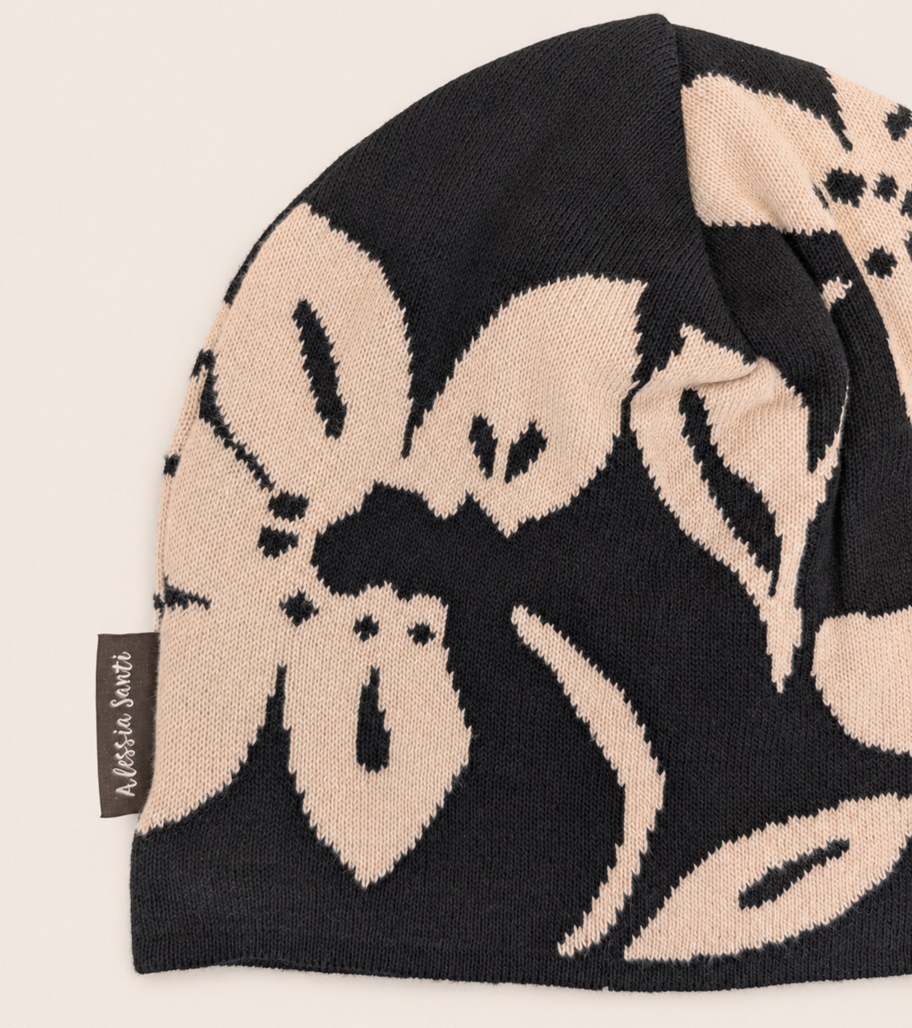 Strikket beanie med blomstermønster i sort og beige