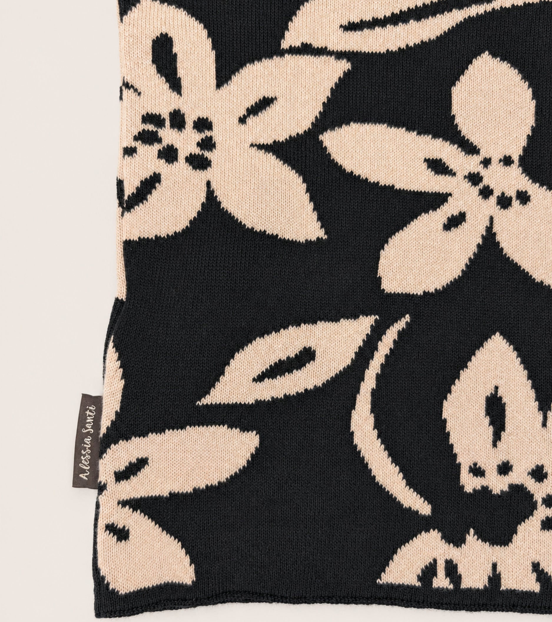 Strikket halsvarmer med blomstermønster i sort og beige