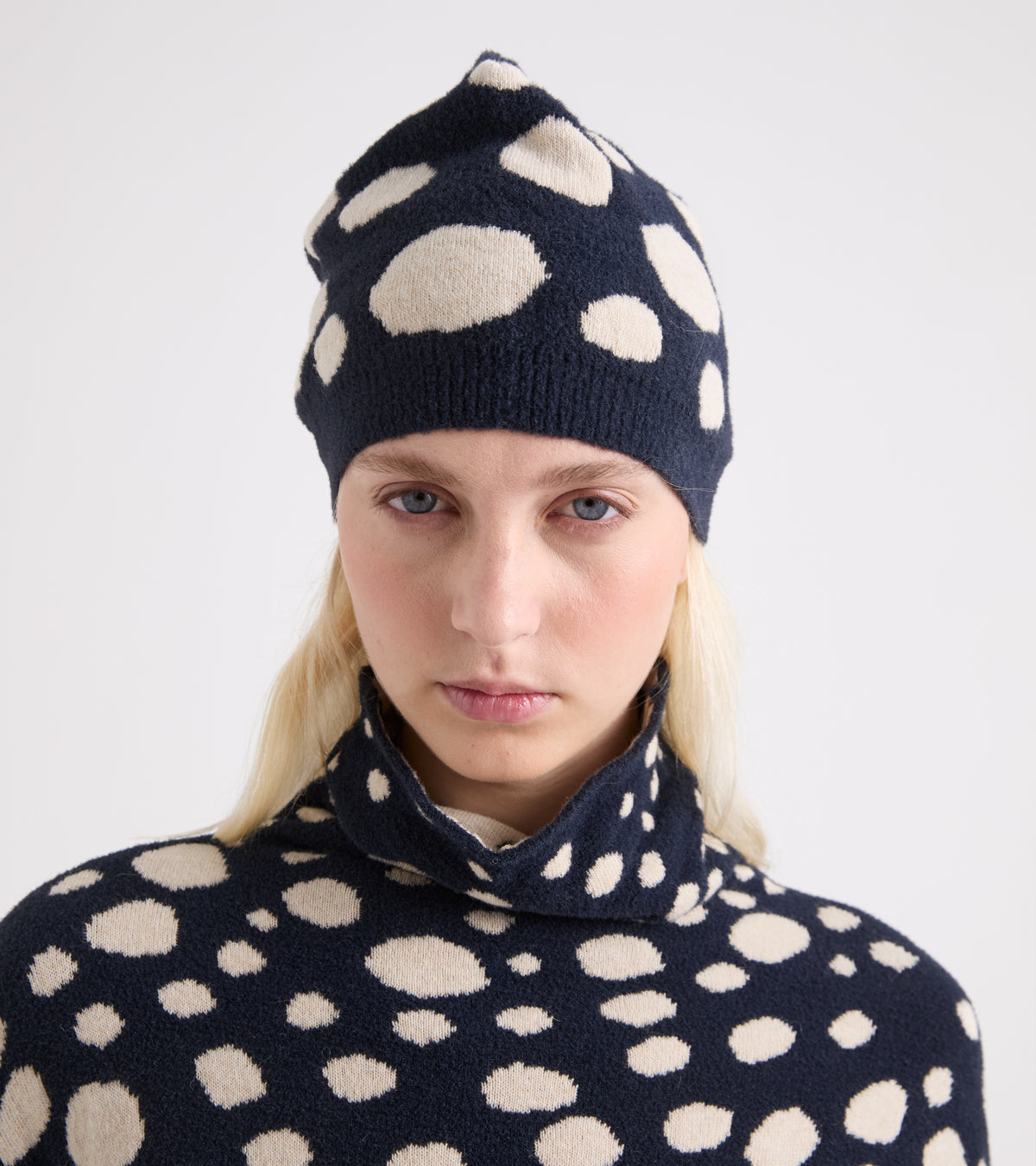 Beanie-hue i et blandet garn af alpaca i farverne beige og navy